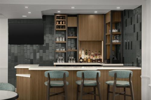 a bar with four stools in a room at Hilton Garden Inn Huntsville/Space Center in Huntsville