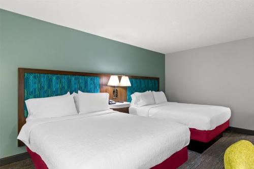 a hotel room with two beds and a chair at Hampton Inn Jacksonville Ponte Vedra in Jacksonville Beach