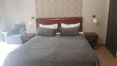 a bedroom with a bed with two pillows and a couch at Villa Tropico śniadanie i obiadokolacja in Pobierowo