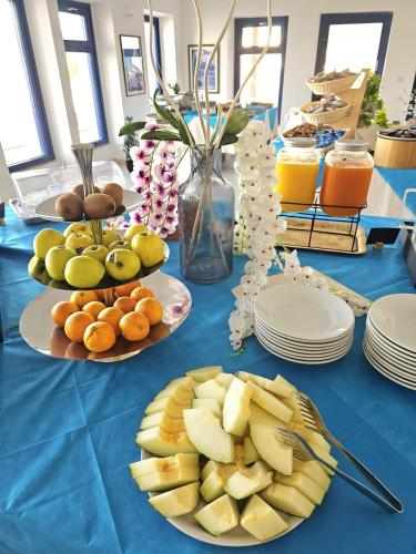a blue table with plates of fruit on it at Vel Marì - Rooms on the Beach in Alghero