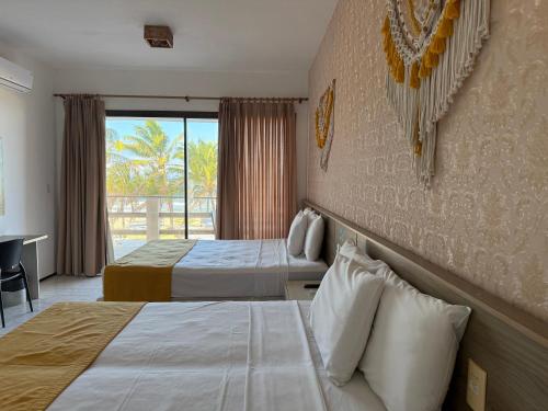 a hotel room with two beds and a balcony at G2 Beach Hotel in Aquiraz