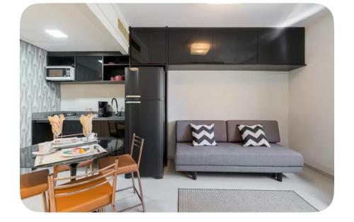 a kitchen and a living room with a couch and a table at Lê premier in São Paulo