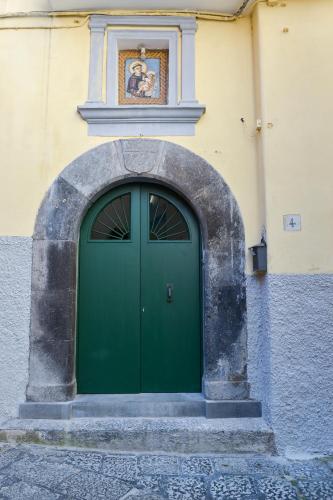 a green door on the side of a building at L'Aurora Azzurra -Luxury Suites Sorrento coast in Piano di Sorrento