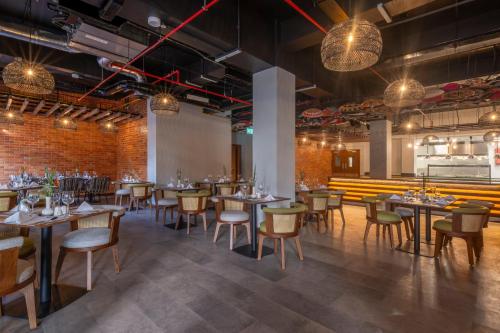 a dining room with tables and chairs and lights at Zaria Court Hotel Kigali in Kigali