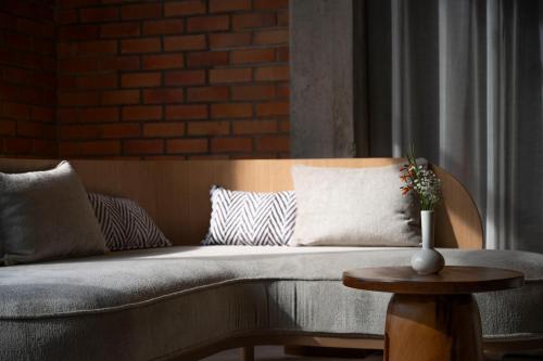 a couch with pillows and a vase on a table at Zaria Court Hotel Kigali in Kigali