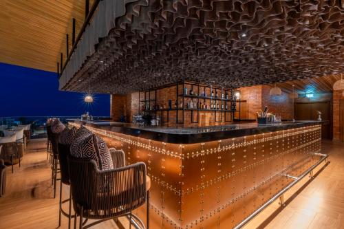 a bar in a restaurant with lights on it at Zaria Court Hotel Kigali in Kigali