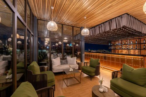 a restaurant with green chairs and tables and chandeliers at Zaria Court Hotel Kigali in Kigali