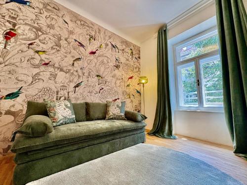 kanapa w pokoju ze ścianą ozdobioną ptakami w obiekcie Beletage Luxury Apartments Graz w Grazu
