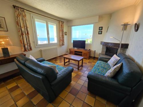 un salon avec deux canapés et une télévision dans l'établissement Évasion bretonne au bord de l'eau, à Plouguerneau