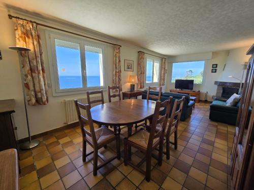 ein Wohnzimmer mit einem Holztisch und Stühlen in der Unterkunft Évasion bretonne au bord de l'eau in Plouguerneau