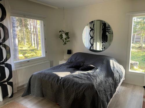 ein Schlafzimmer mit einem Bett und einem Spiegel an der Wand in der Unterkunft Villa Väinölä, tilaa rauhoittua in Alavus