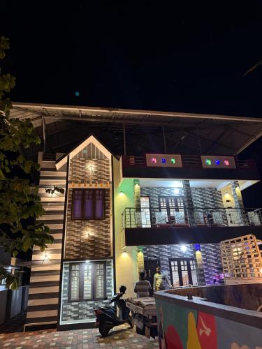 a building with a scooter parked in front of it at night at Costal elegance homestay in Varkala