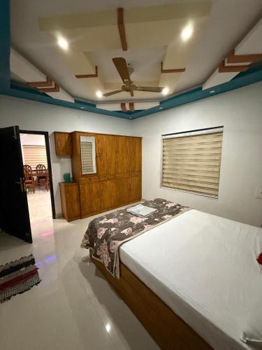 a bedroom with a bed and a ceiling fan at Costal elegance homestay in Varkala
