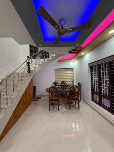 a dining room with a ceiling fan and a table at Costal elegance homestay in Varkala