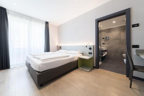 a bedroom with a large bed and a bathroom at Garda Life in Riva del Garda