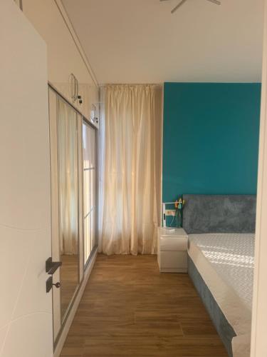 a bedroom with a bed and a large window at Sinemorets Blue apartments in Sinemorets