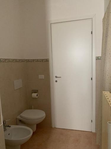 a bathroom with a toilet and a white door at Tra Fiori e Antichità in Cerchiara