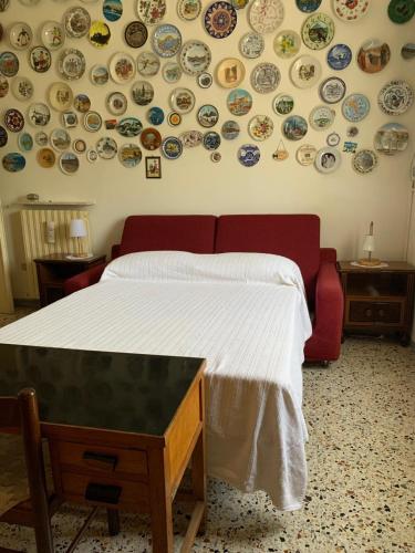 a bedroom with a bed with plates on the wall at Tra Fiori e Antichità in Cerchiara
