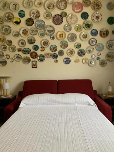 a bedroom with a wall with plates on the wall at Tra Fiori e Antichità in Cerchiara