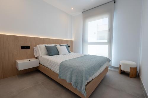 a bedroom with a large bed and a window at As Casas do Castro "Curota" in A Pobra do Caramiñal