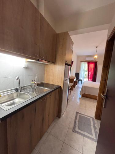 a kitchen with a sink and a kitchen with a bed at Παντέλειο in Karistos