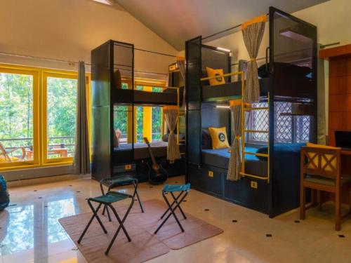 チクマガルールにあるThe Hosteller Chikmagalurの二段ベッド2台と椅子2脚のある部屋