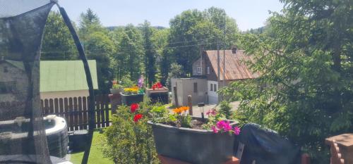 a garden with flowers in pots on a balcony at Penzion V Kopci in Kořenov