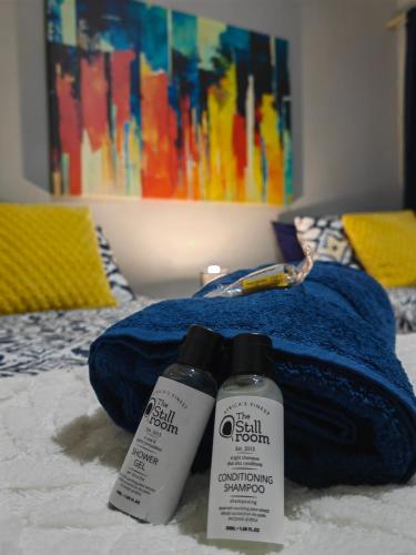 two bottles of sunscreen sitting on top of a bed at Pelican Palms Aston Jeffreys Bay in Jeffreys Bay