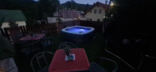 a backyard with a hot tub and a table and chairs at Penzion V Kopci in Kořenov
