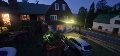 a car parked in front of a house at night at Penzion V Kopci in Kořenov
