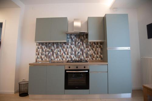a kitchen with white cabinets and a refrigerator at FLAIC b&b in Pergusa
