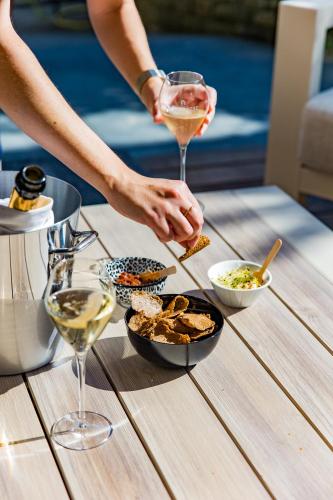 a person with a glass of wine and food on a table at Hôtel Le D'Avaugour in Dinan