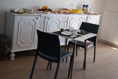 a table and chairs in a kitchen with a white cabinet at FLAIC b&b in Pergusa