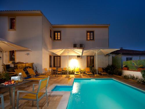 a villa with a swimming pool in front of a house at Betica Hotel Rural in Pias
