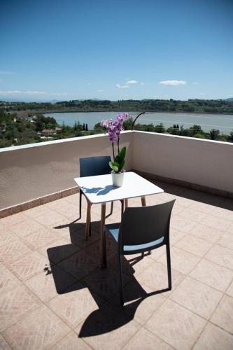 a table and two chairs on a balcony with a table and flowers at FLAIC b&b in Pergusa