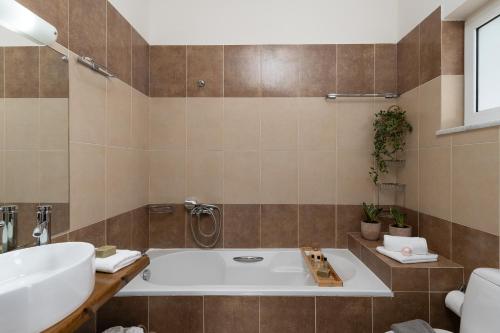 a bathroom with a tub and a sink at Pithos Apartment in Korakiaí