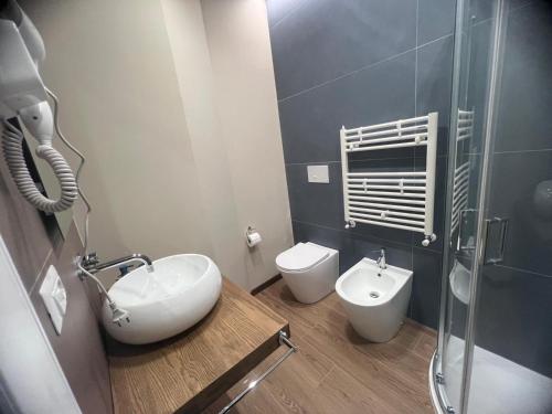 a bathroom with a sink and a toilet and a shower at FLAIC b&b in Pergusa