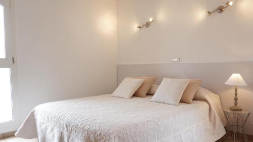 エス・カロにあるAstbury Apartments Ses Bassesの白いベッド(白いシーツ、枕付)