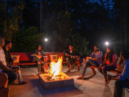 チクマガルールにあるThe Hosteller Chikmagalurの夜、火の周りに座っている人々のグループ