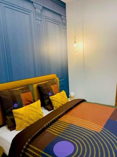 a bed with colorful pillows on it in a room at Appartement hyper centre Balcon in Périgueux