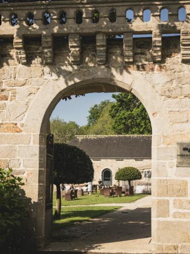 an archway leading into a building with a yard at Manoir de Kerhuel de Quimper in Plonéour-Lanvern