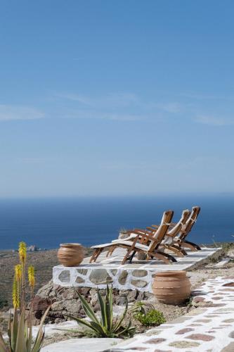 a group of chairs sitting on top of a beach at Castrum Traditional Sunset Suites in Plaka Milou