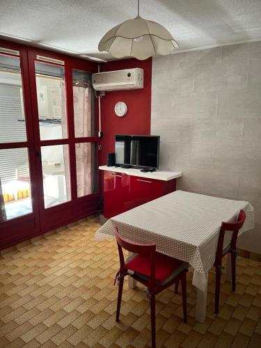 une cuisine avec une table, deux chaises et un four micro-ondes dans l'établissement Le Volvire 31, au Cap d'Agde