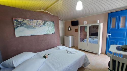a bedroom with a white bed and a blue door at Niriides Apartments & Studio in Vathi