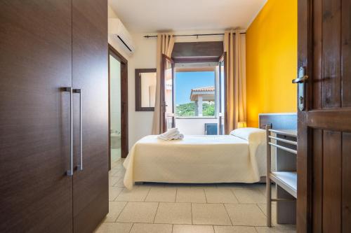a hotel room with a bed and a window at Hotel Marina in Badesi
