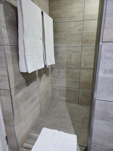 a shower with two towels hanging on a wall at Schnehage Self Catering in Bloemfontein