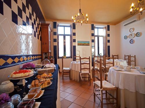 un restaurant avec des tables et des chaises avec de la nourriture dessus dans l'établissement Betica Hotel Rural, à Pias