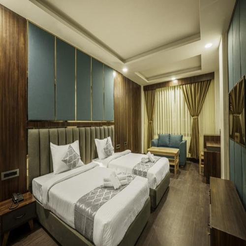 a hotel room with two beds and a chair at Royal Potala in Gangtok
