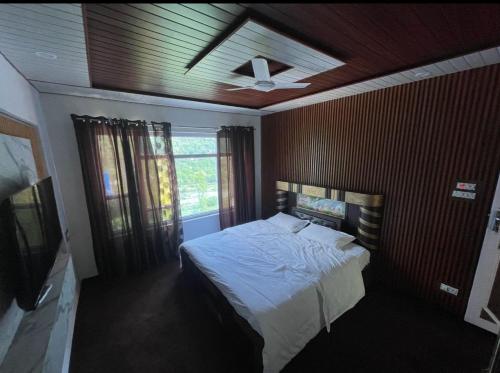 a bedroom with a bed and a ceiling fan at ROYALE PEAKS Sonamarg rd in Sonāmarg