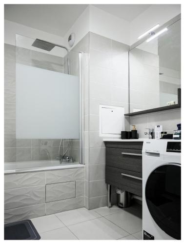 - une cuisine blanche avec une baignoire et un évier dans l'établissement Paisible 3 pièces, proche de Paris avec parking, à Romainville